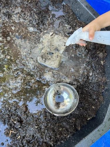 Bevroren zand ontdooien met een plantenspuit met lauwwarm  water.