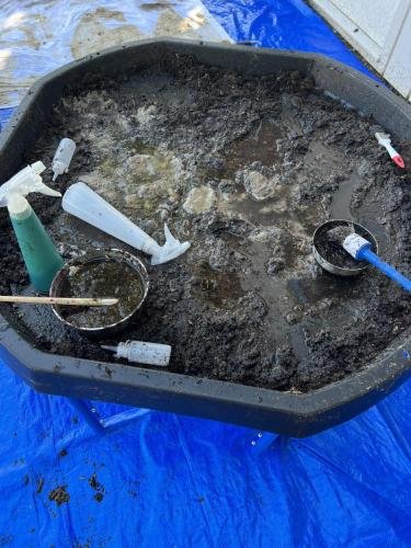 Bevroren zand ontdooien met een plantenspuit met lauwwarm  water.