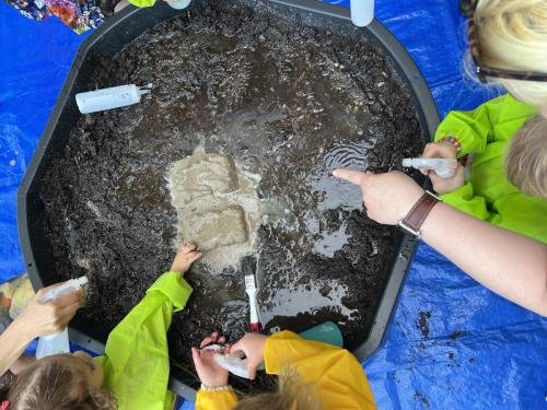 Bevroren zand ontdooien met een plantenspuit met lauwwarm  water.