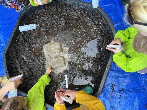 Bevroren zand ontdooien met een plantenspuit met lauwwarm  water.